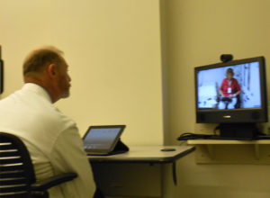 photo of Dr. Daniel A. Albert communicating with a nurse using telemedicine technology.